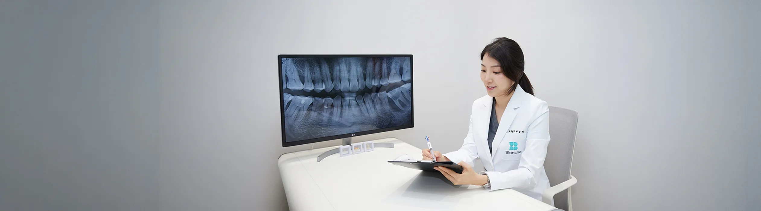 블랑쉬치과 교정 전문의가 X-ray를 보며 골격과 교합을 고려한 치아교정 상담을 진행하는 모습