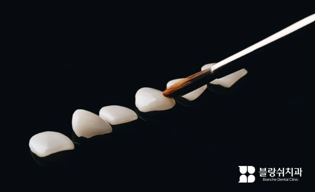 검은색 배경 위 붓으로 정교하게 제작 중인 블랑쉬 라미네이트