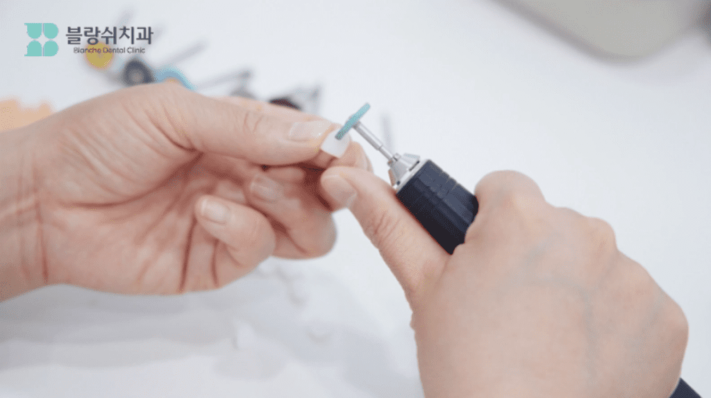 치科技工士が前歯ラミネートを精巧に整えている様子