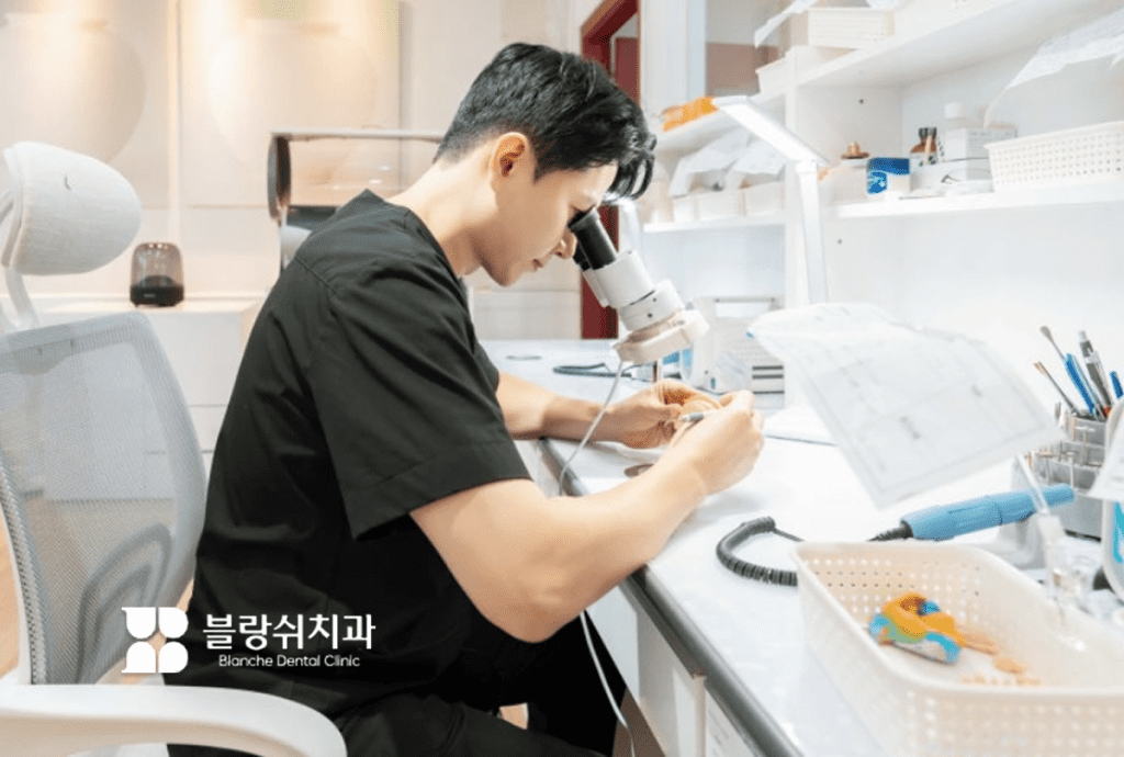 ブランシュ歯科の医療陣が顕微鏡で精密ラミネート加工中の様子